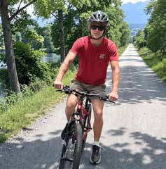 Finn Erlandson riding his bike on a tree lined trail