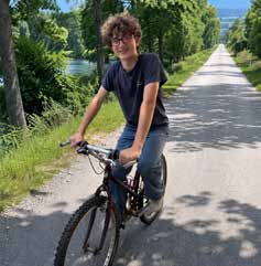 Nathan Romboldi riding his bike on a tree lined trail