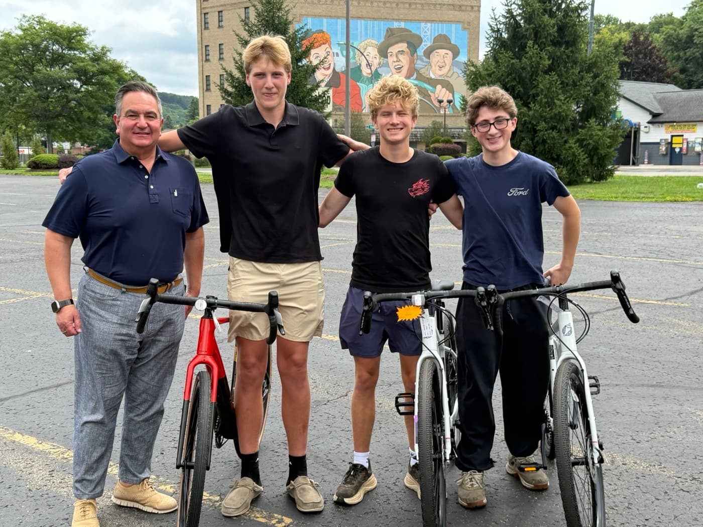 New York State Senator George Borrello standing with Nick, Finn, and Nathan and their loaded bikes before the start of the ride